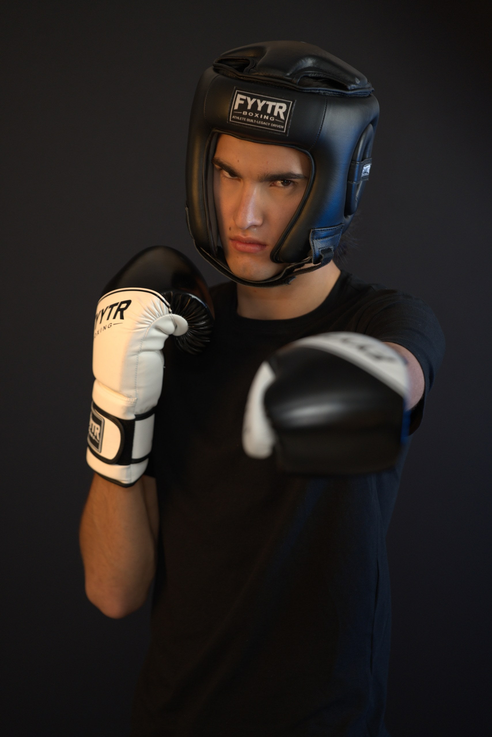 Boxer in a black FYYTR headguard and white training gloves