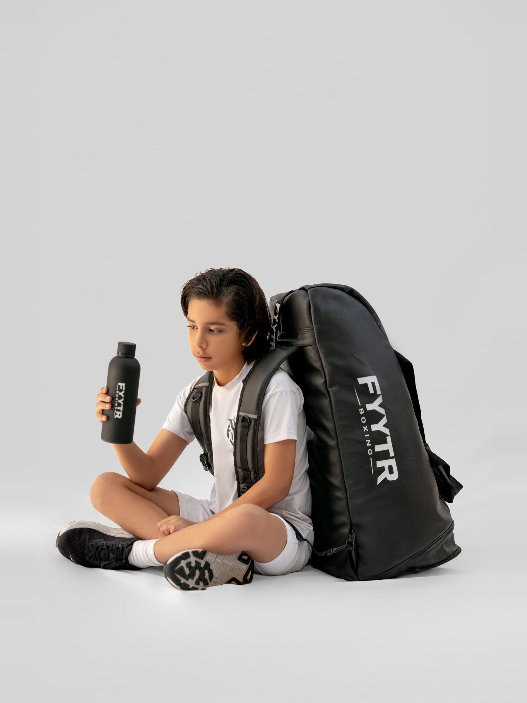 Athlete seated with a FYYTR kit bag and water bottle
