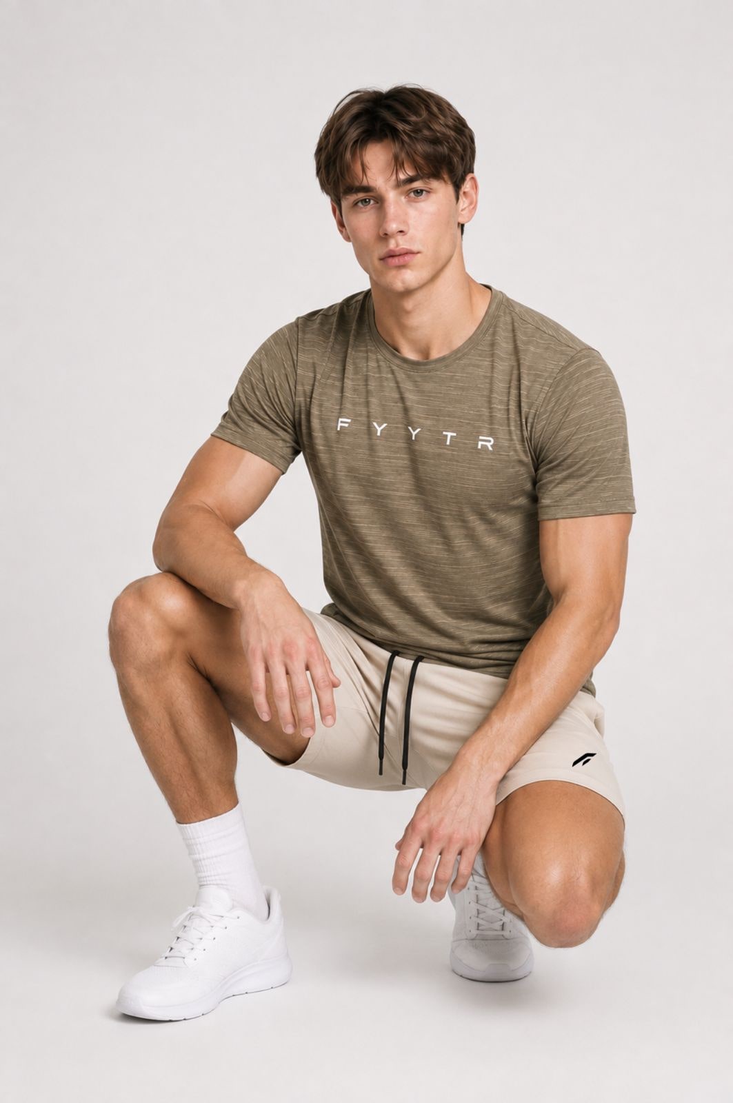 Man in a khaki FYYTR Hustle Tee and training shorts