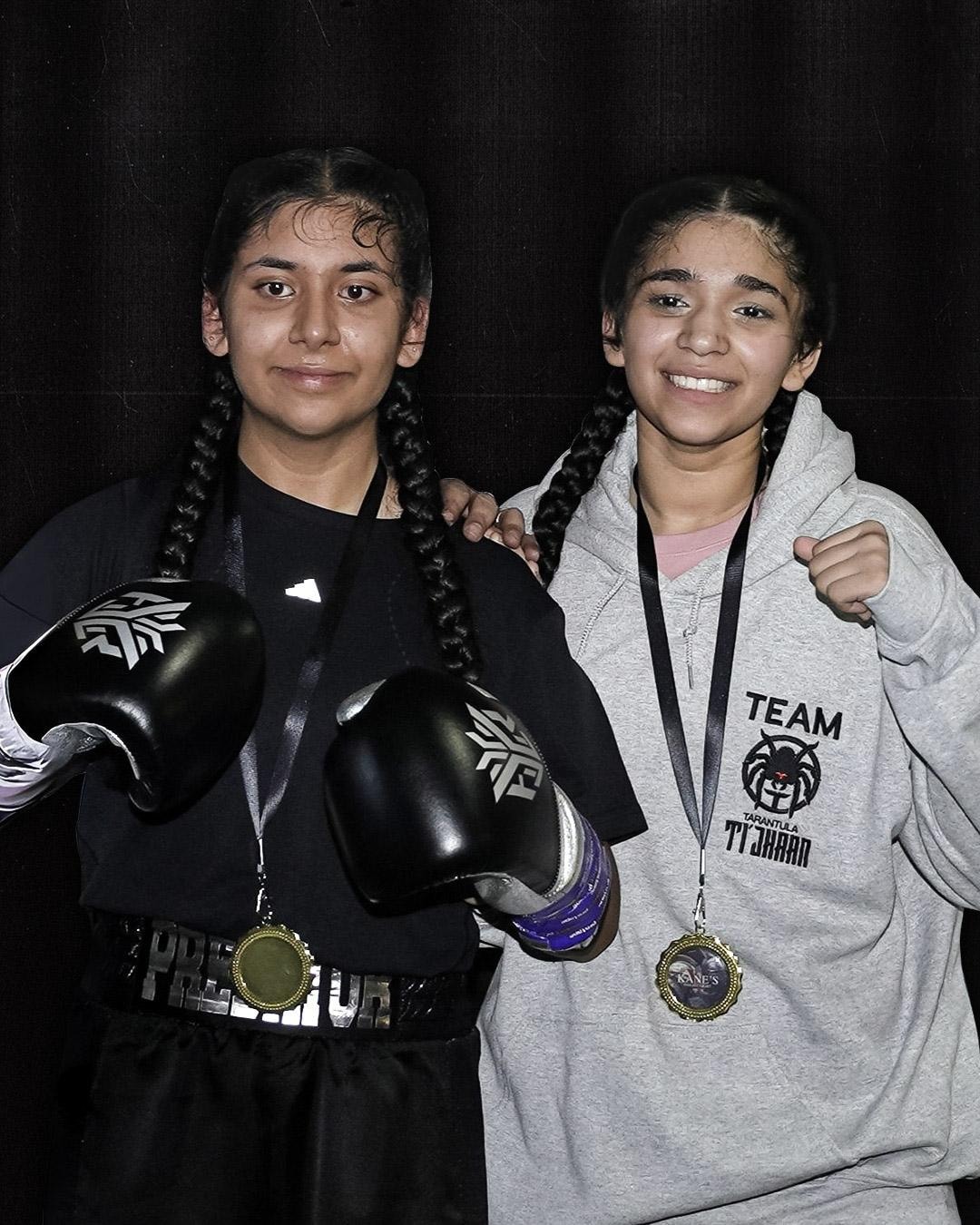 Two young boxers smiling and wearing medals after a competition